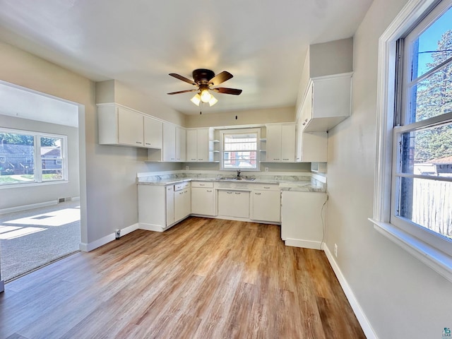 kitchen with ceiling fan, light hardwood / wood-style flooring, sink, and white cabinetry