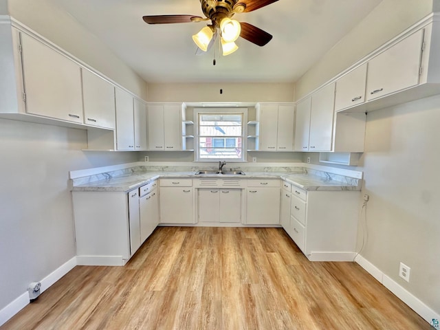 kitchen with sink, white cabinets, light hardwood / wood-style flooring, and ceiling fan