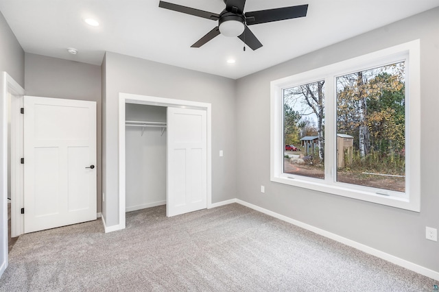 unfurnished bedroom featuring a closet, light carpet, and ceiling fan