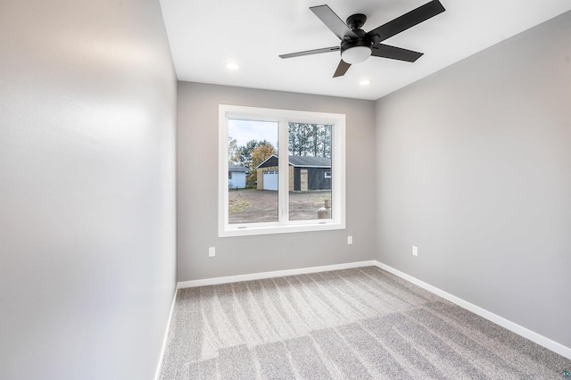 carpeted spare room with ceiling fan