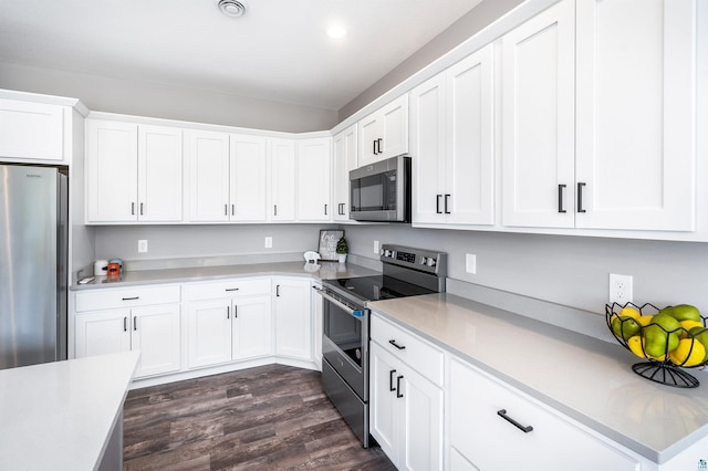 kitchen featuring appliances with stainless steel finishes, dark hardwood / wood-style flooring, and white cabinets