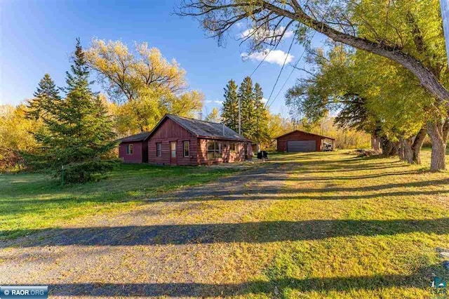 view of yard featuring a garage and an outbuilding