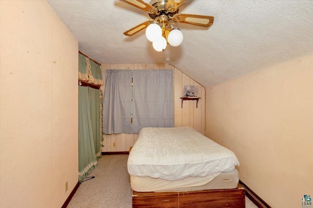 bedroom featuring ceiling fan, light carpet, a textured ceiling, and vaulted ceiling