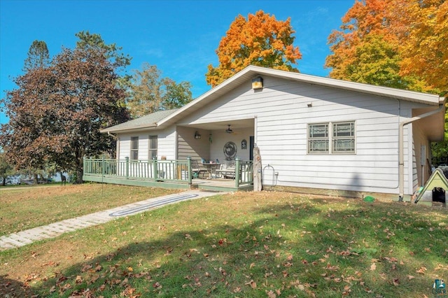 view of front of house with a wooden deck and a front yard