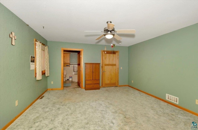 unfurnished bedroom featuring ceiling fan, ensuite bathroom, and carpet floors