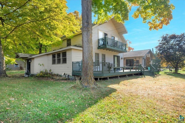 rear view of house featuring a wooden deck, a yard, and a balcony