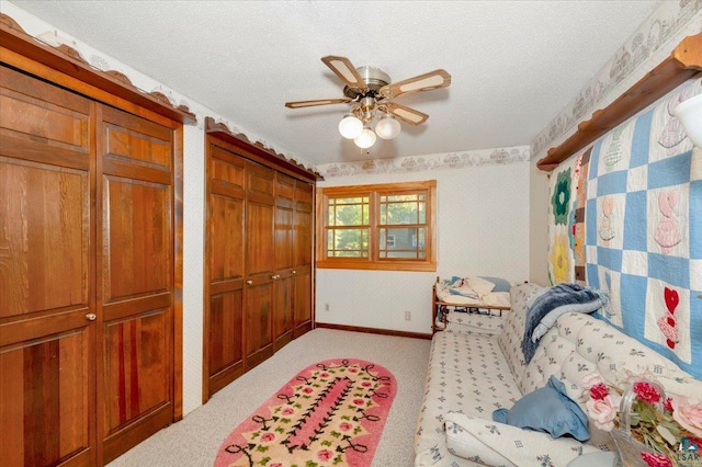 carpeted bedroom featuring ceiling fan and a textured ceiling