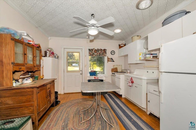 kitchen with white appliances, white cabinetry, ceiling fan, crown molding, and light hardwood / wood-style flooring