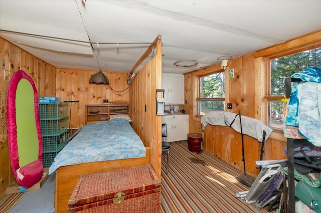 bedroom with wood walls and dark carpet