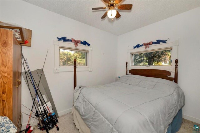 carpeted bedroom featuring a textured ceiling and ceiling fan