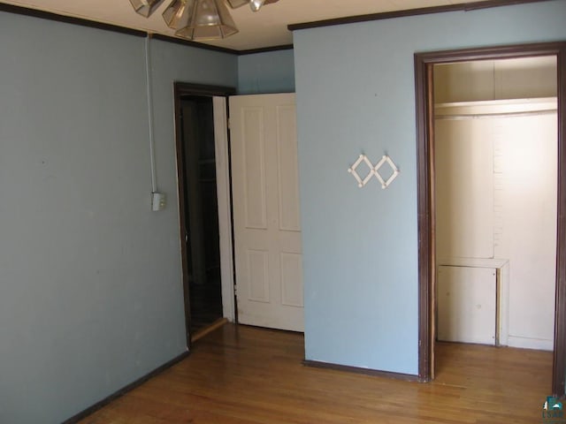 21 White St, Ely, MN 55731 - unfurnished bedroom featuring wood finished floors, baseboards, and crown molding