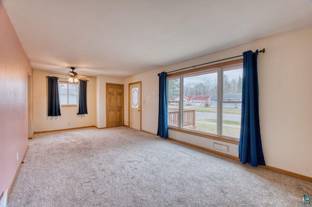 carpeted spare room with ceiling fan