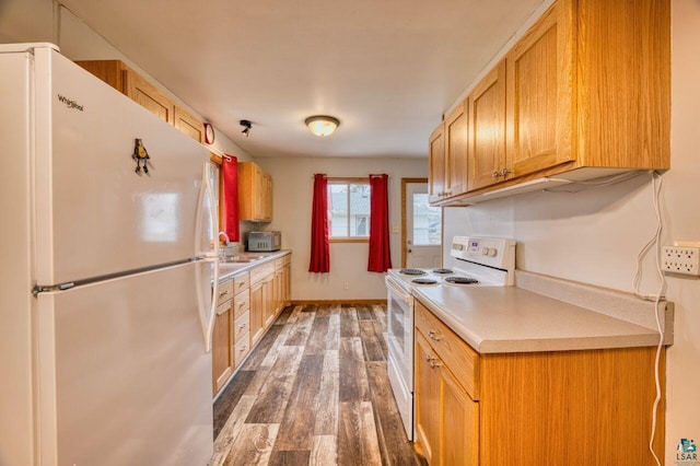 kitchen featuring white appliances and dark hardwood / wood-style floors