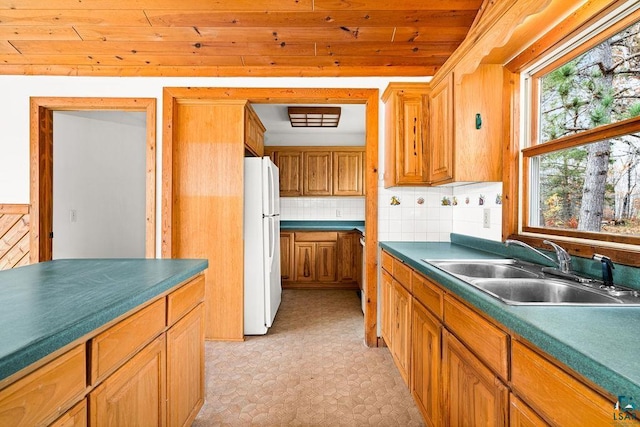 kitchen featuring decorative backsplash, sink, wooden ceiling, and white refrigerator