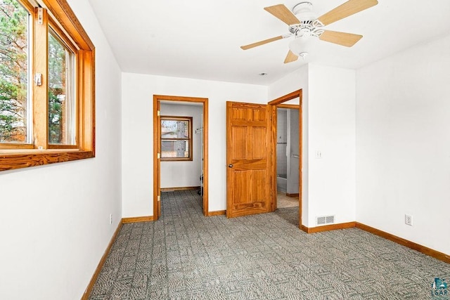 unfurnished bedroom with a walk in closet, carpet floors, and ceiling fan