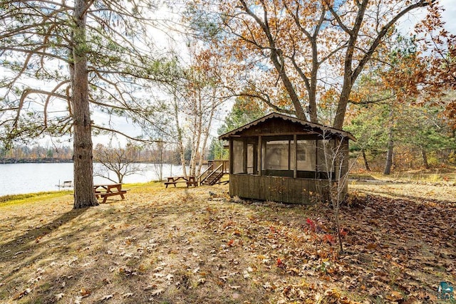 view of yard with a water view and a sunroom