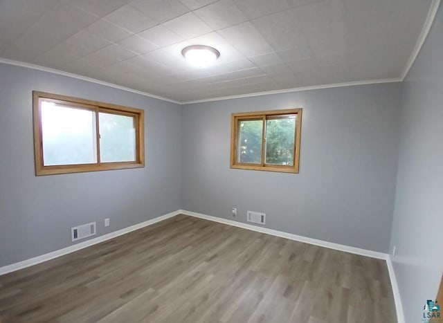 unfurnished room featuring ornamental molding and hardwood / wood-style floors