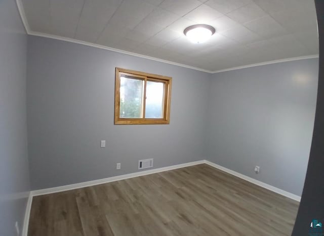 spare room with hardwood / wood-style floors and crown molding