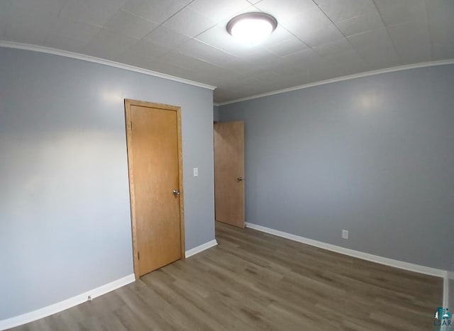 empty room featuring ornamental molding and hardwood / wood-style flooring