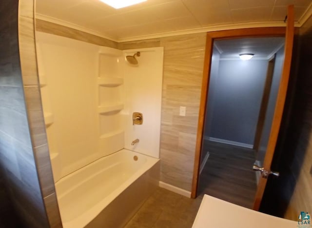 bathroom with tile patterned floors, crown molding, and washtub / shower combination