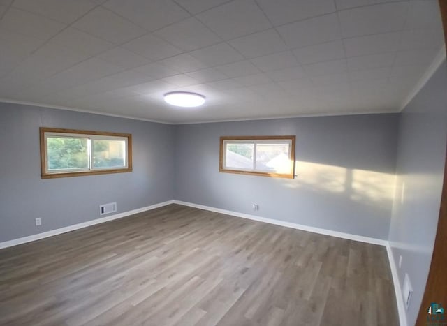 unfurnished room featuring crown molding and wood-type flooring