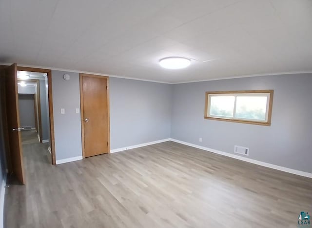 spare room with crown molding and light hardwood / wood-style floors