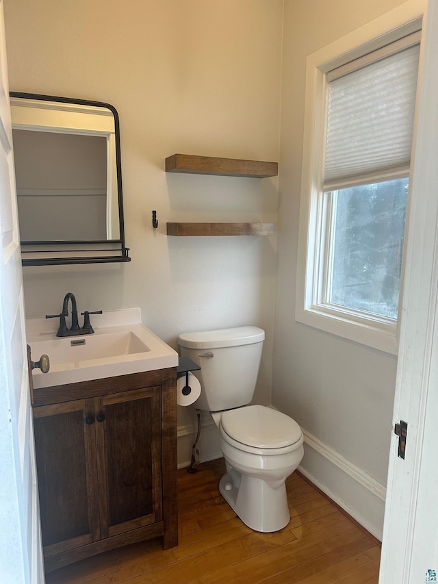 bathroom featuring vanity, toilet, and hardwood / wood-style floors