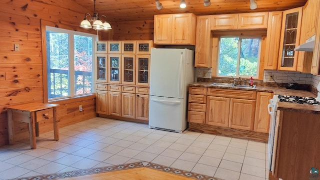 kitchen with wooden ceiling, wood walls, pendant lighting, sink, and white appliances