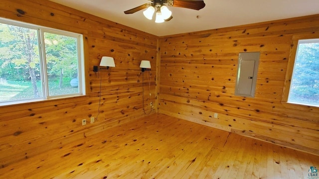 empty room featuring hardwood / wood-style flooring, electric panel, and plenty of natural light