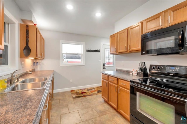 kitchen featuring light tile patterned flooring, sink, and black appliances