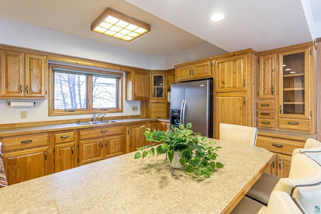 kitchen with sink, stainless steel fridge with ice dispenser, and a breakfast bar