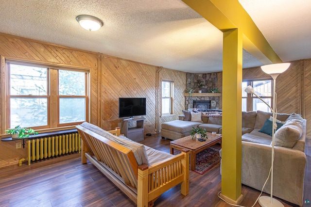 living room with a textured ceiling, radiator heating unit, and dark hardwood / wood-style floors