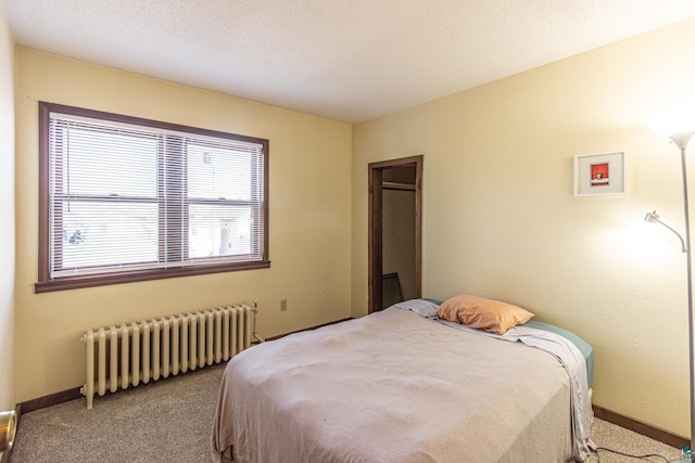 bedroom with light colored carpet, a textured ceiling, and radiator