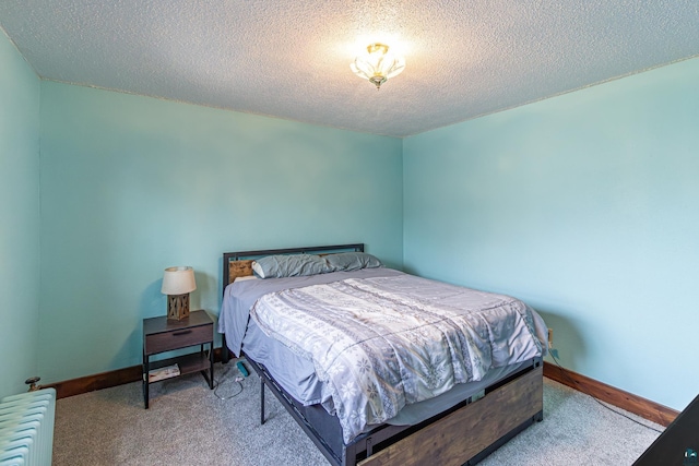 bedroom featuring carpet flooring, radiator heating unit, and a textured ceiling