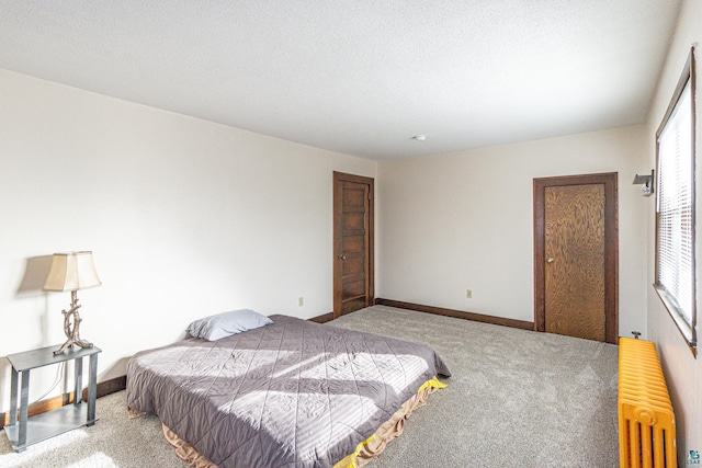 bedroom with carpet floors, a textured ceiling, and radiator