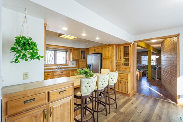 kitchen featuring a kitchen bar, sink, hardwood / wood-style flooring, and stainless steel fridge