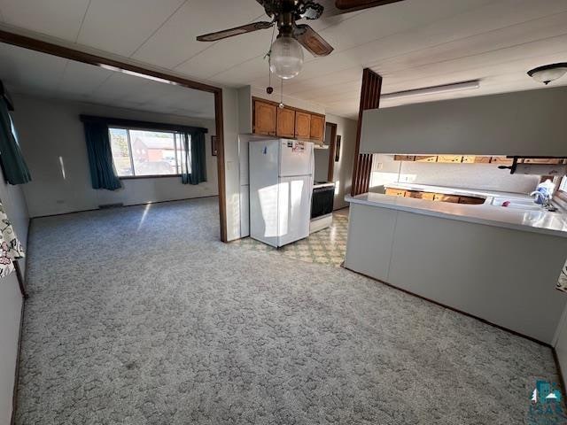 kitchen featuring ceiling fan, light carpet, and white fridge