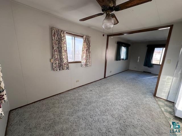 carpeted spare room featuring ceiling fan