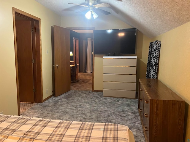 unfurnished bedroom with carpet flooring, a textured ceiling, ceiling fan, and vaulted ceiling