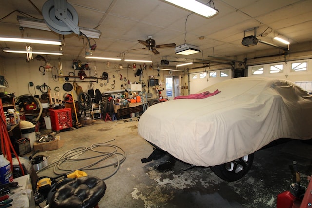 garage with a workshop area, ceiling fan, and a garage door opener