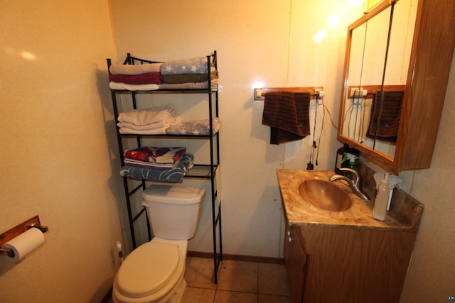 bathroom with toilet, vanity, and tile patterned floors