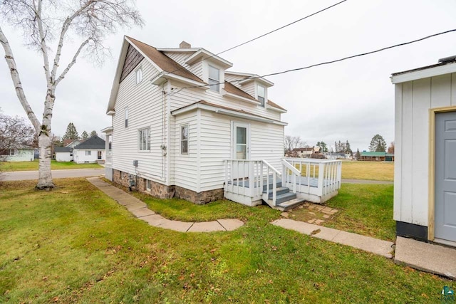 view of side of home featuring a yard and a deck