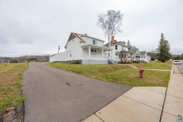 view of front of home featuring covered porch and a front lawn