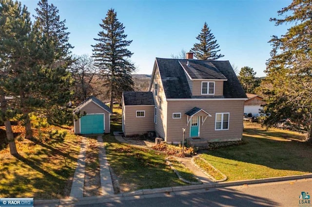 view of front of property featuring a garage, a front lawn, and an outdoor structure