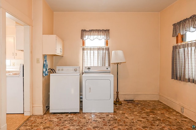 clothes washing area featuring cabinets and washing machine and dryer