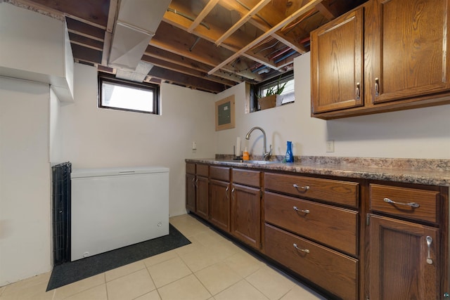 kitchen featuring sink, light tile patterned flooring, and fridge