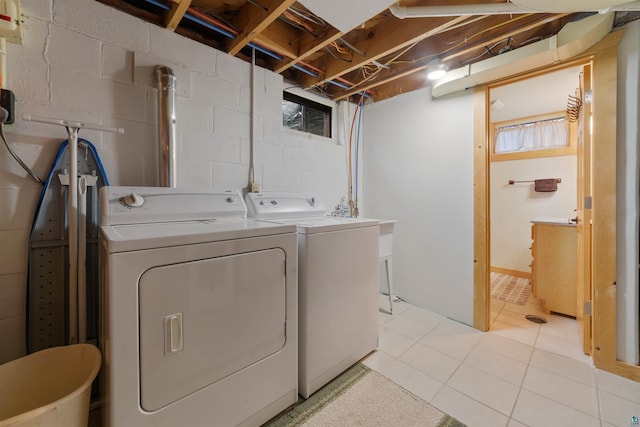 clothes washing area featuring light tile patterned floors and separate washer and dryer