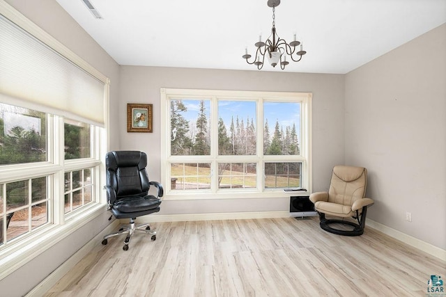living area with an inviting chandelier and light hardwood / wood-style flooring