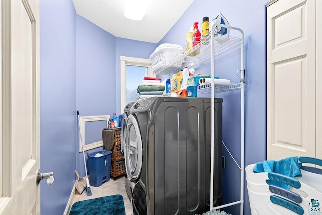 laundry area with washer and clothes dryer and light tile patterned floors