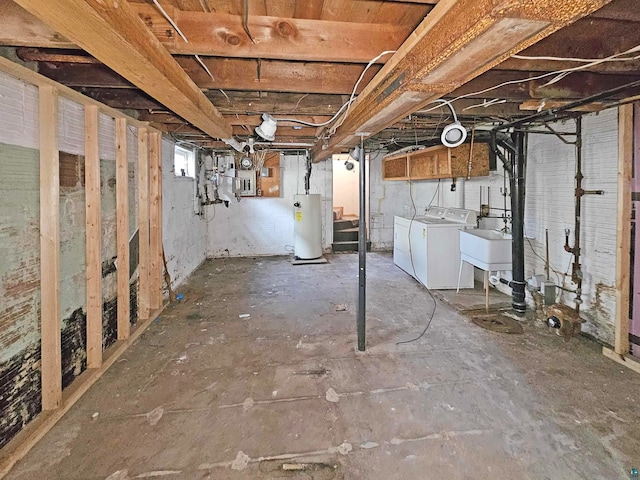 basement featuring washing machine and dryer, gas water heater, and sink